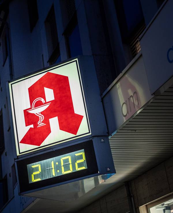 Eine digitale Uhr an einer Apotheke in Köln zeigt am Abend die Uhrzeit 21.02 Uhr an.