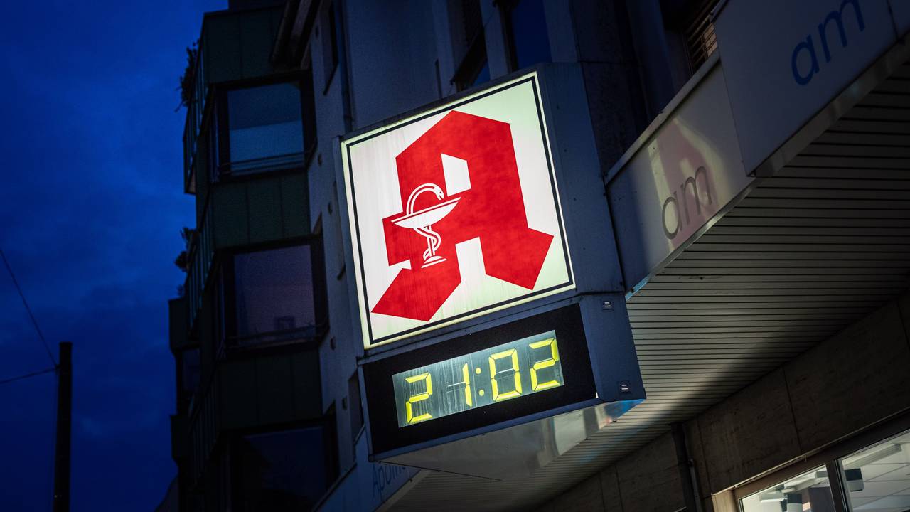 Eine digitale Uhr an einer Apotheke in Köln zeigt am Abend die Uhrzeit 21.02 Uhr an.