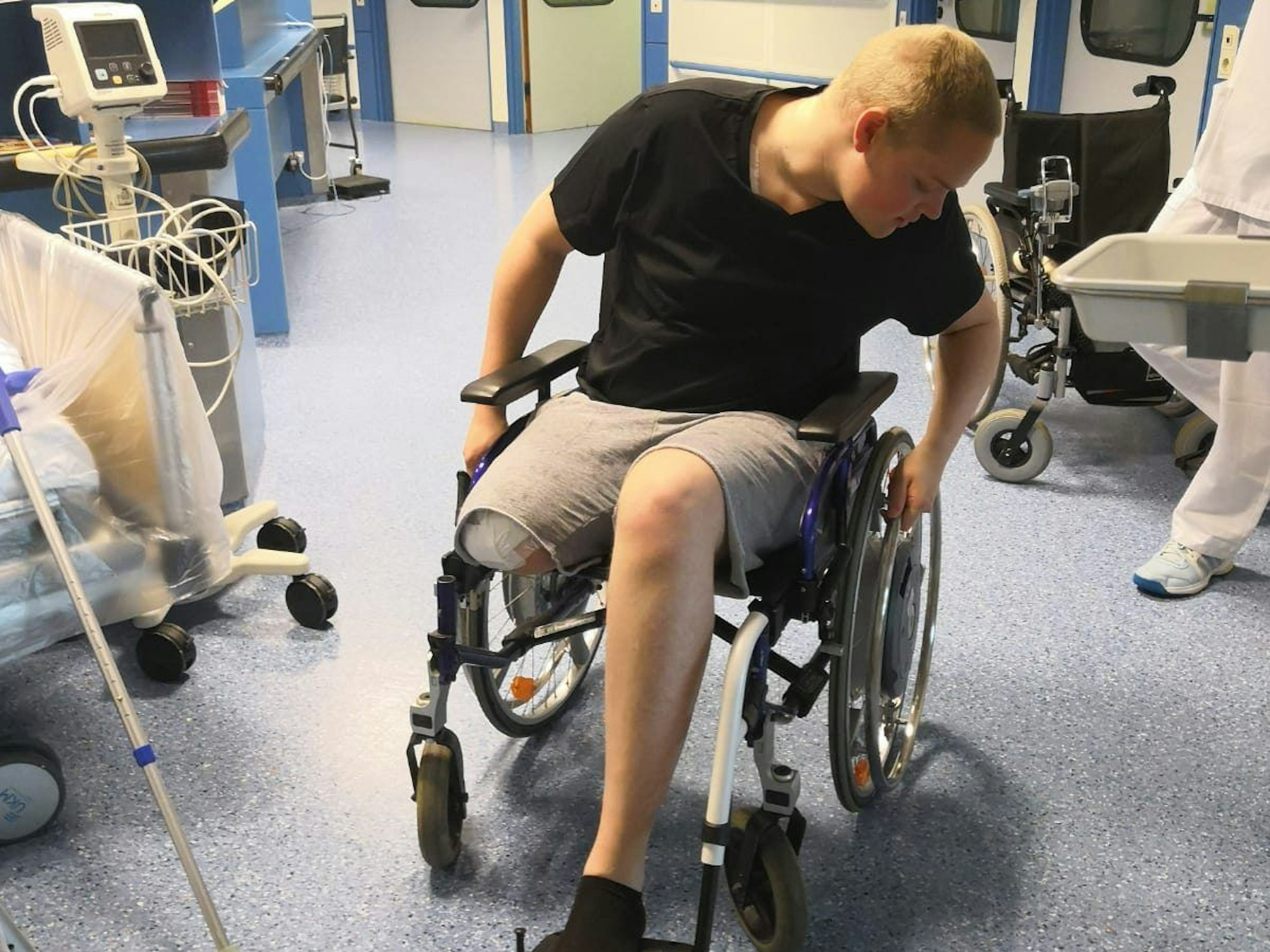 Alexander aus Köln mit Beinstumpf in einem Rollstuhl im Krankenhaus.