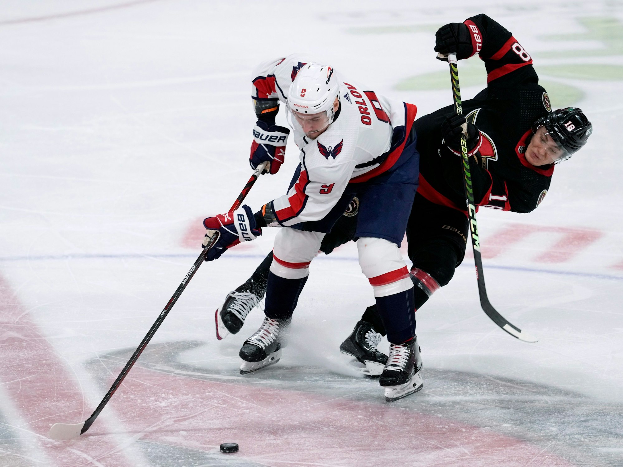 Senators Tim Stützle (r.) versucht Capitals-Verteidiger Dmitry Orlov den Puck abzunehmen.