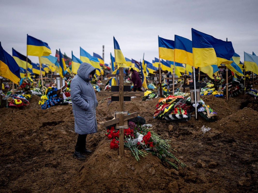 Eine Frau betrachtet das Grab ihres Mannes, einem ukrainischen Soldaten, der an der Frontlinie gestorben ist.