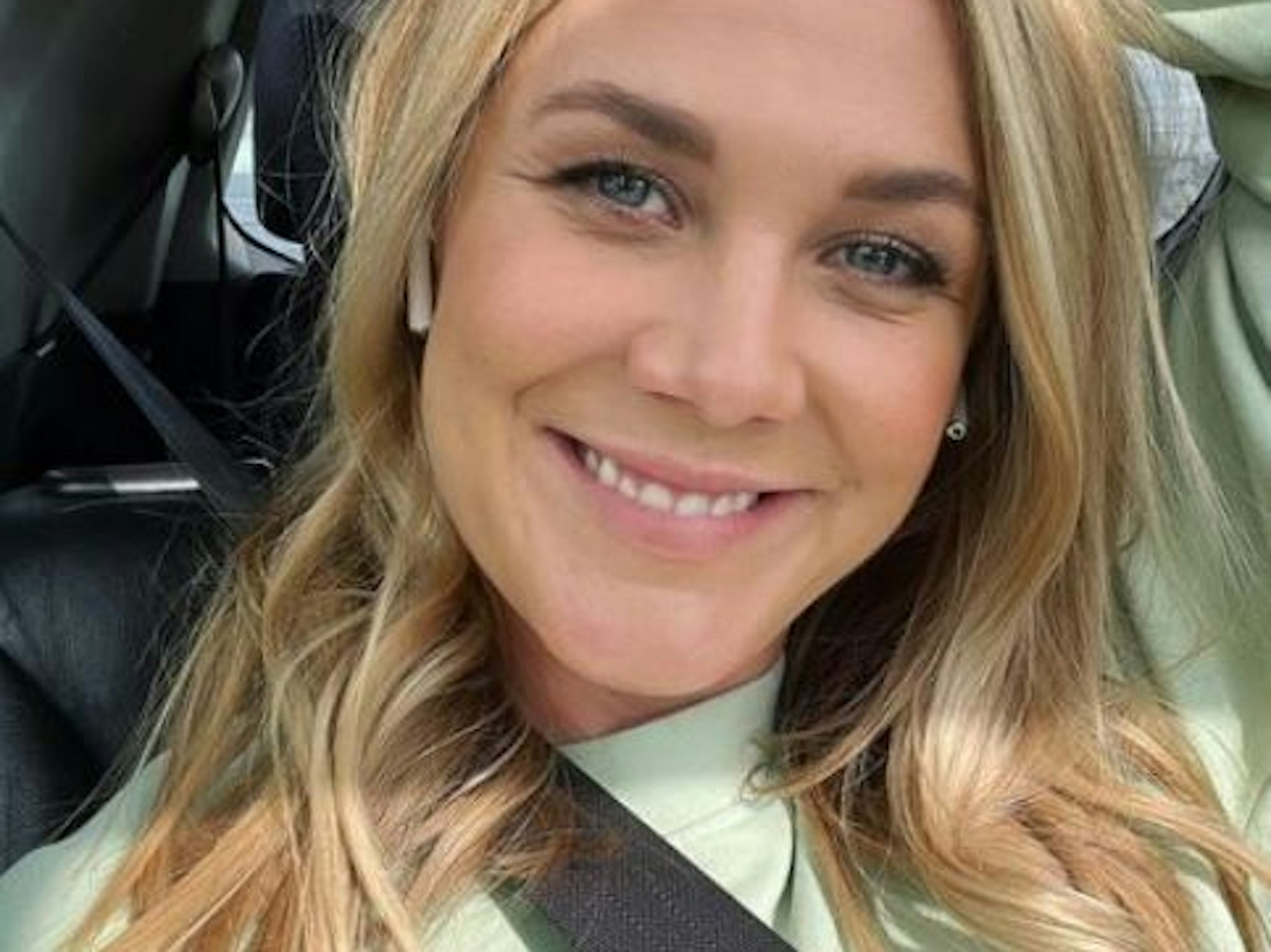 Alina Merkau sitzt im Auto und grinst in die Kamera.