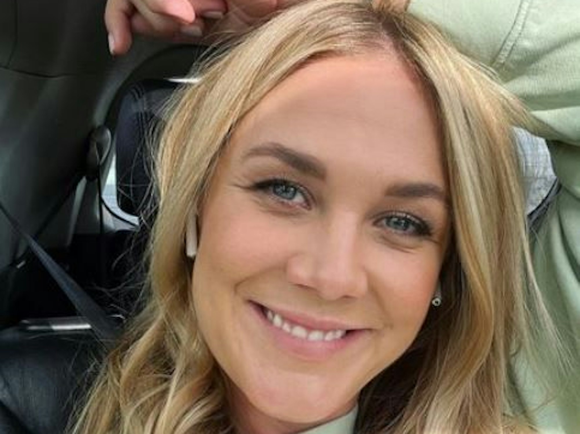 Alina Merkau sitzt im Auto und grinst in die Kamera.