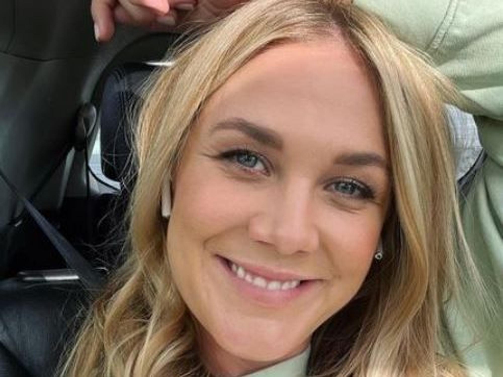 Alina Merkau sitzt im Auto und grinst in die Kamera.