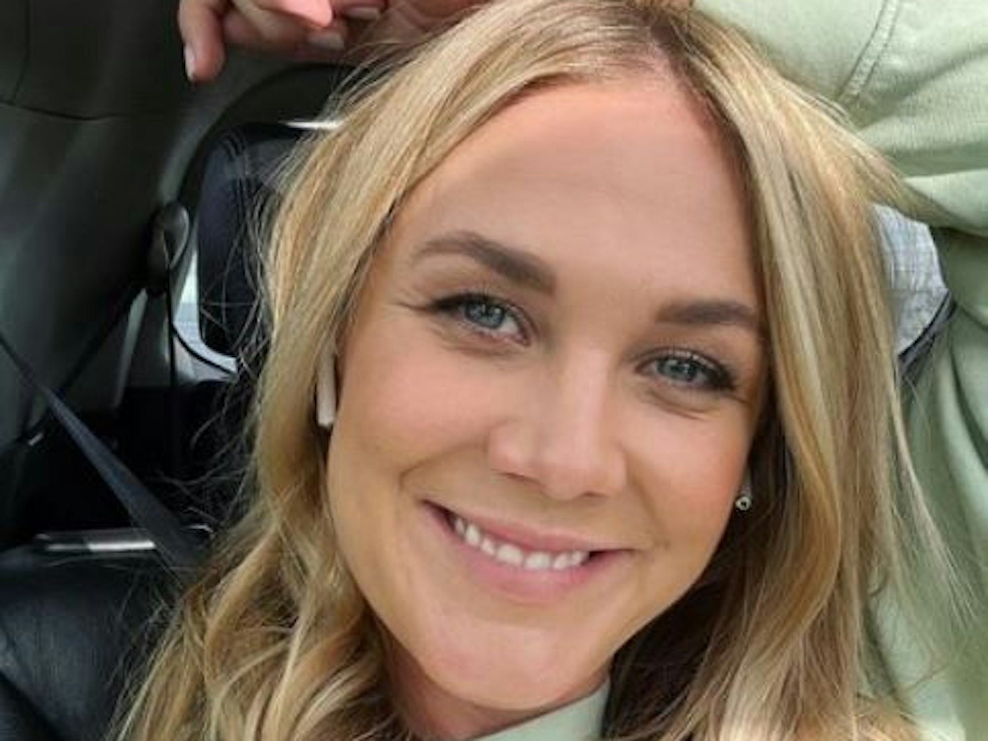 Alina Merkau sitzt im Auto und grinst in die Kamera.