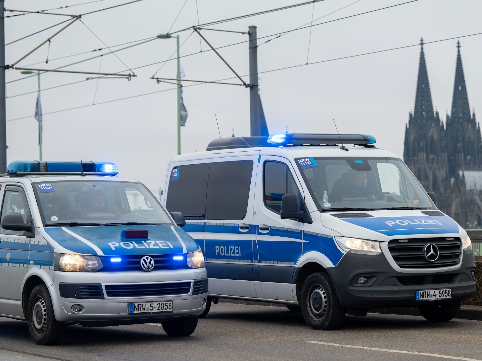 Einsatzfahrzeuge der Polizei fahren über die Deutzer Brücke.