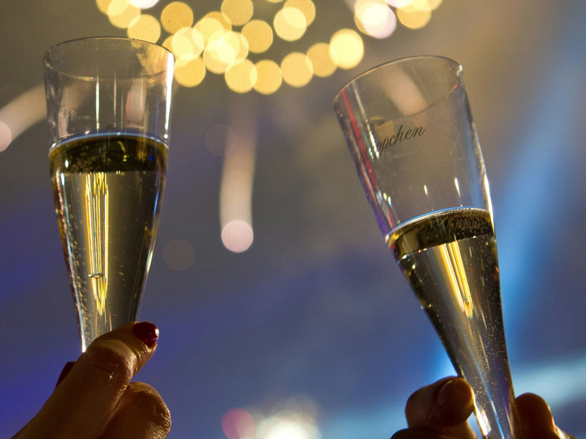 Das Foto zeigt Feiernde, die im in der Silvesternacht von 2013 auf 2014 am Brandenburger Tor in Berlin mit Sektgläsern anstoßen. Auch in der Nacht vom Jahreswechsel von 2022 auf 2023 wird kräftig angestoßen. Um dem lästigen Kater am nächsten Tag vorzubeugen, gib es nun einige Tipps.