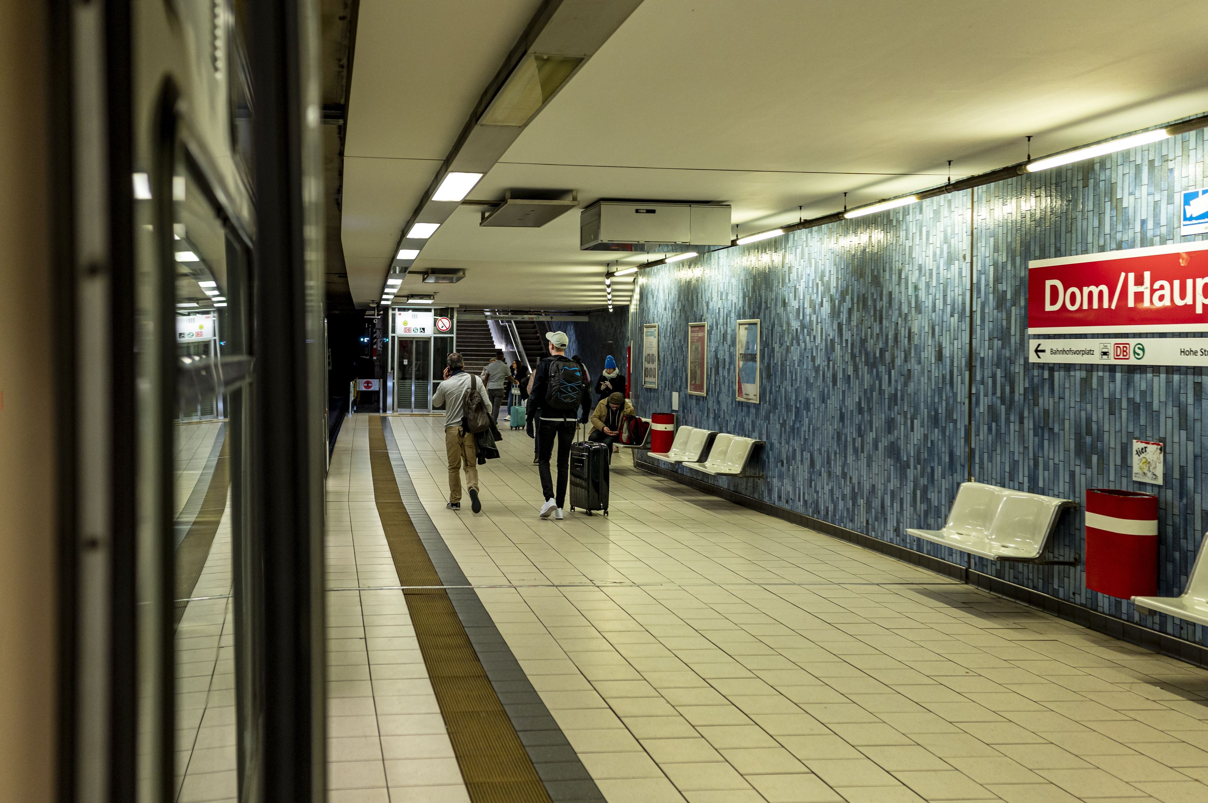 Menschen steigen am fast leeren Bahnsteig der KVB am Kölner Hauptbahnhof aus.