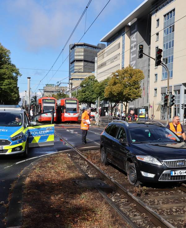 Schwarzer Ford steht in Köln im Gleisbett. Daneben stehen Autos der Polizei, im Hintergrund müssen Bahnen der KVB warten.
