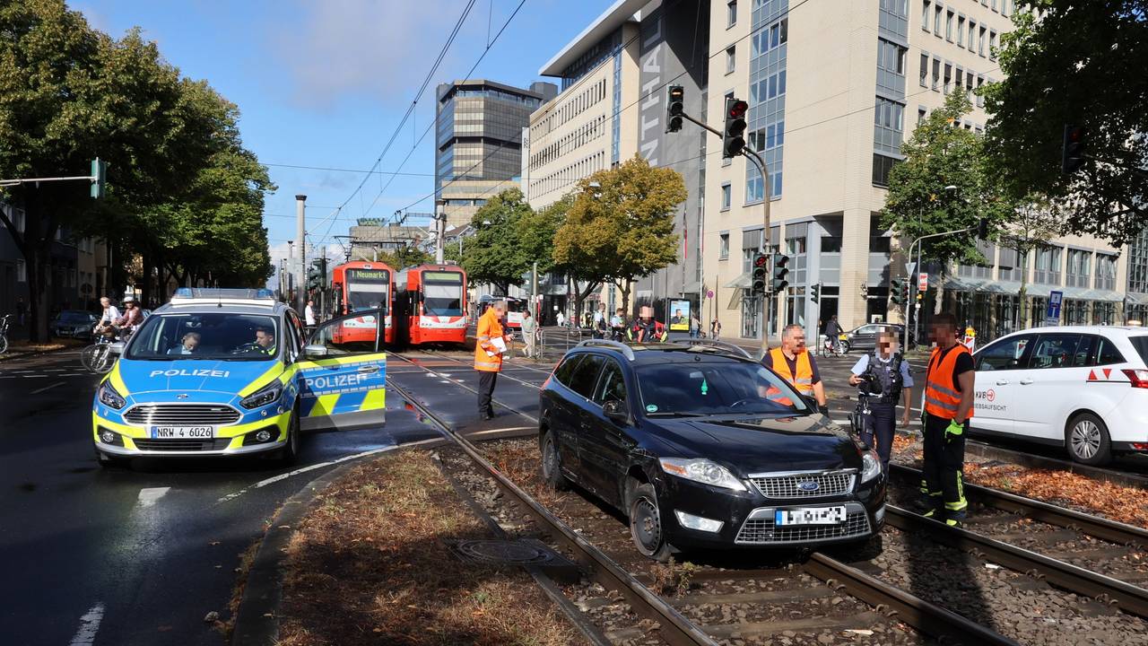 Schwarzer Ford steht in Köln im Gleisbett. Daneben stehen Autos der Polizei, im Hintergrund müssen Bahnen der KVB warten.