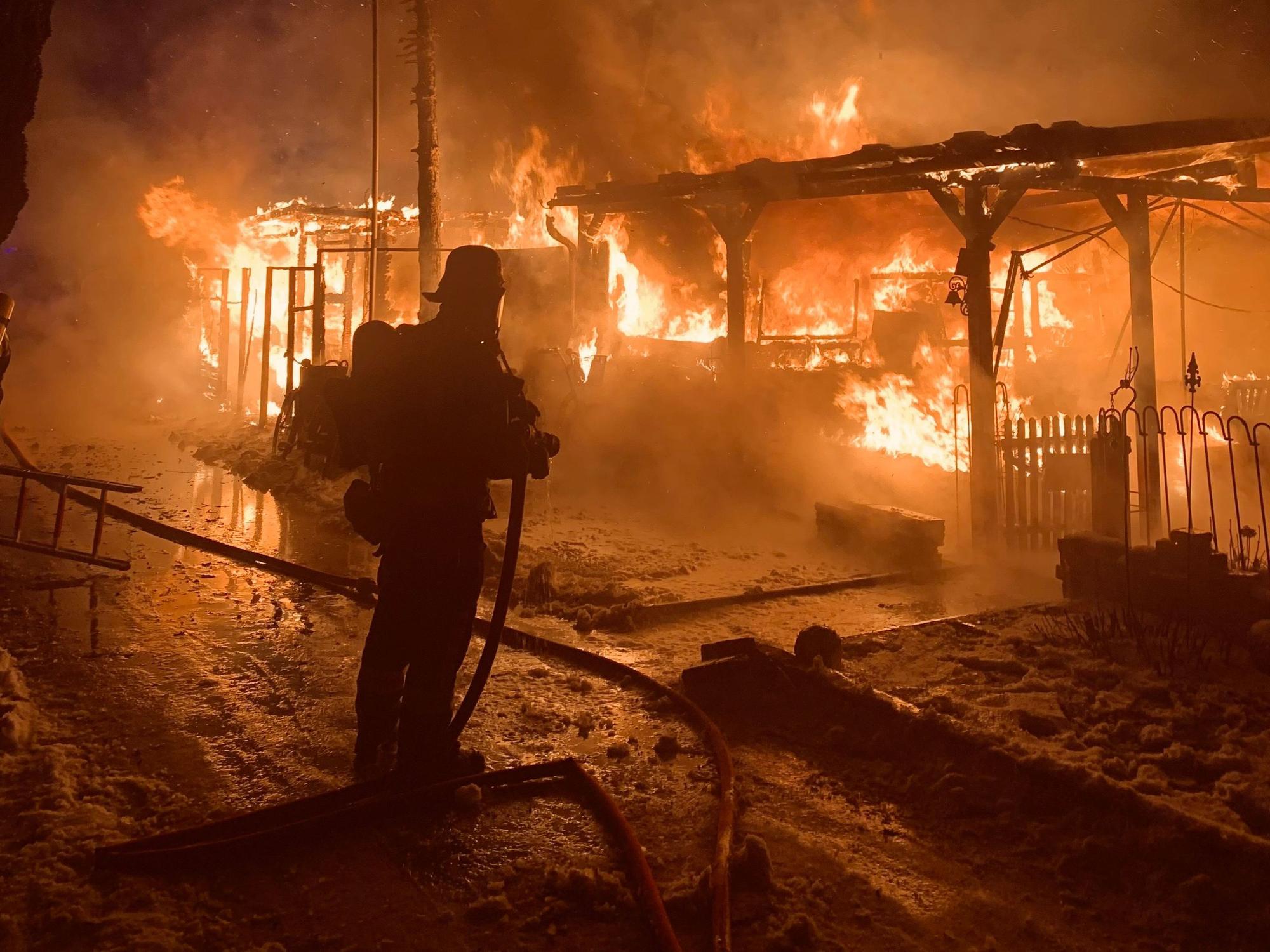 Ein Mitglied der Augsburger Feuerwehr bekämpft ein Feuer auf einem Campingplatz.