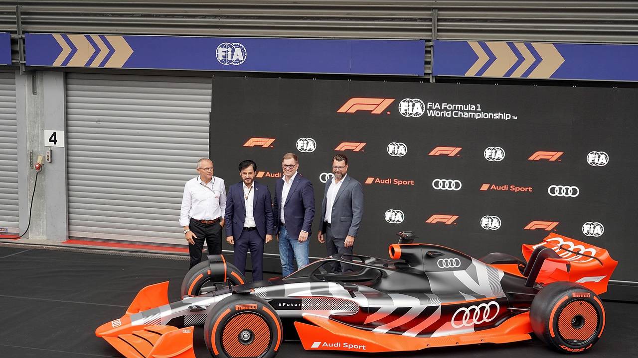 Formel-1-CEO Stefano Domenicali, FIA-Präsident Mohammed bin Sulayem, Audi-Vorstandschef Markus Duesmann und Audi-CTO Oliver Hoffmann stehen hinter einem Model des Formel-1-Autos von Audi.