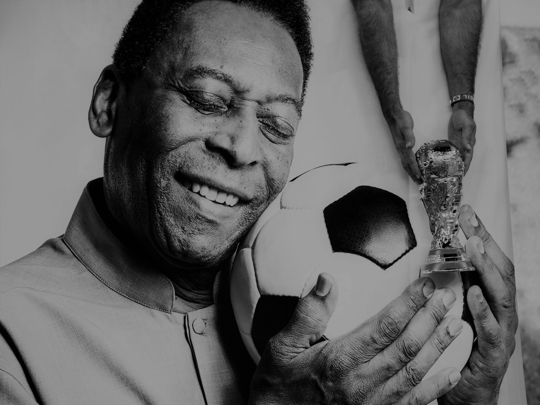 Pelé hält einen Fußball in seinen Händen.