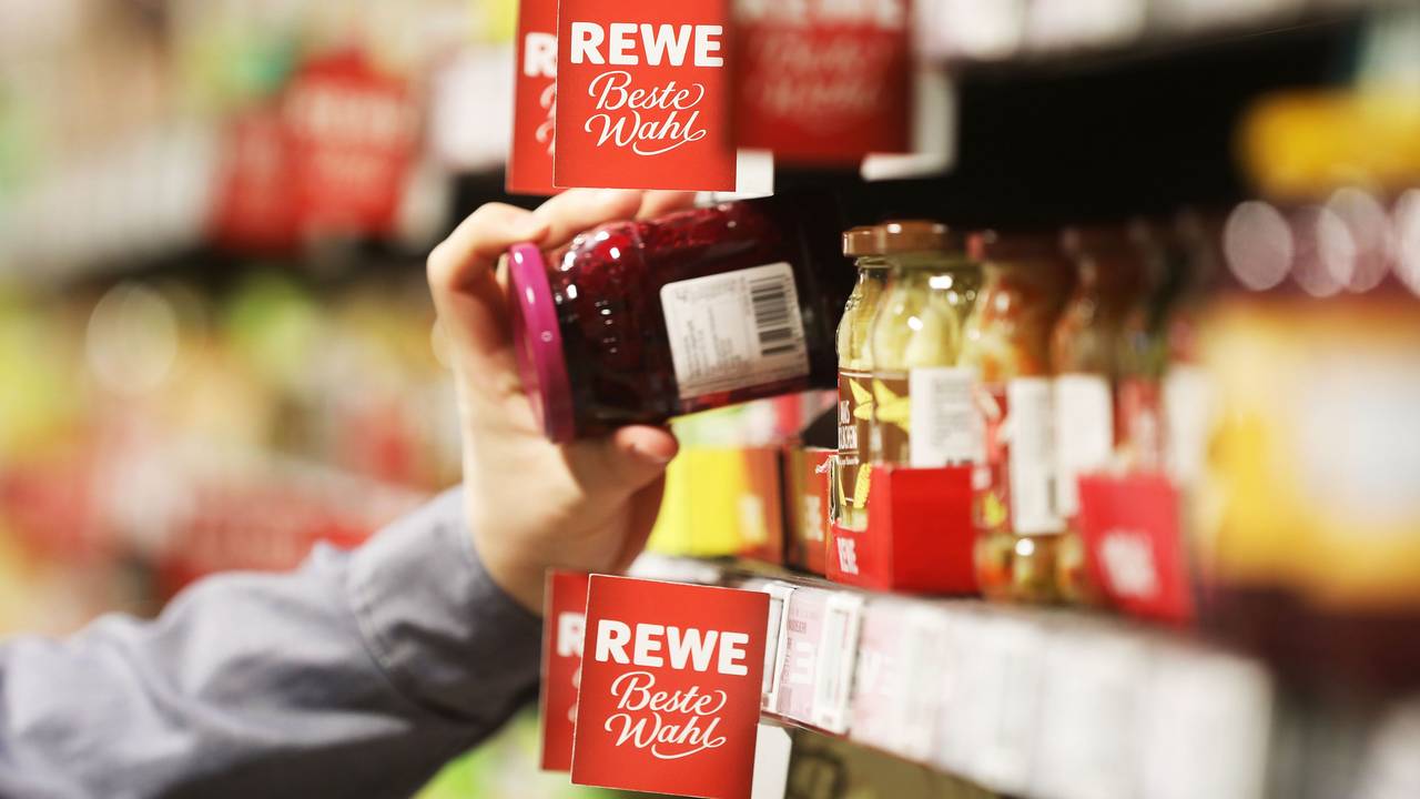 Ein Kunde an einem Supermarkt-Regal bei Rewe.