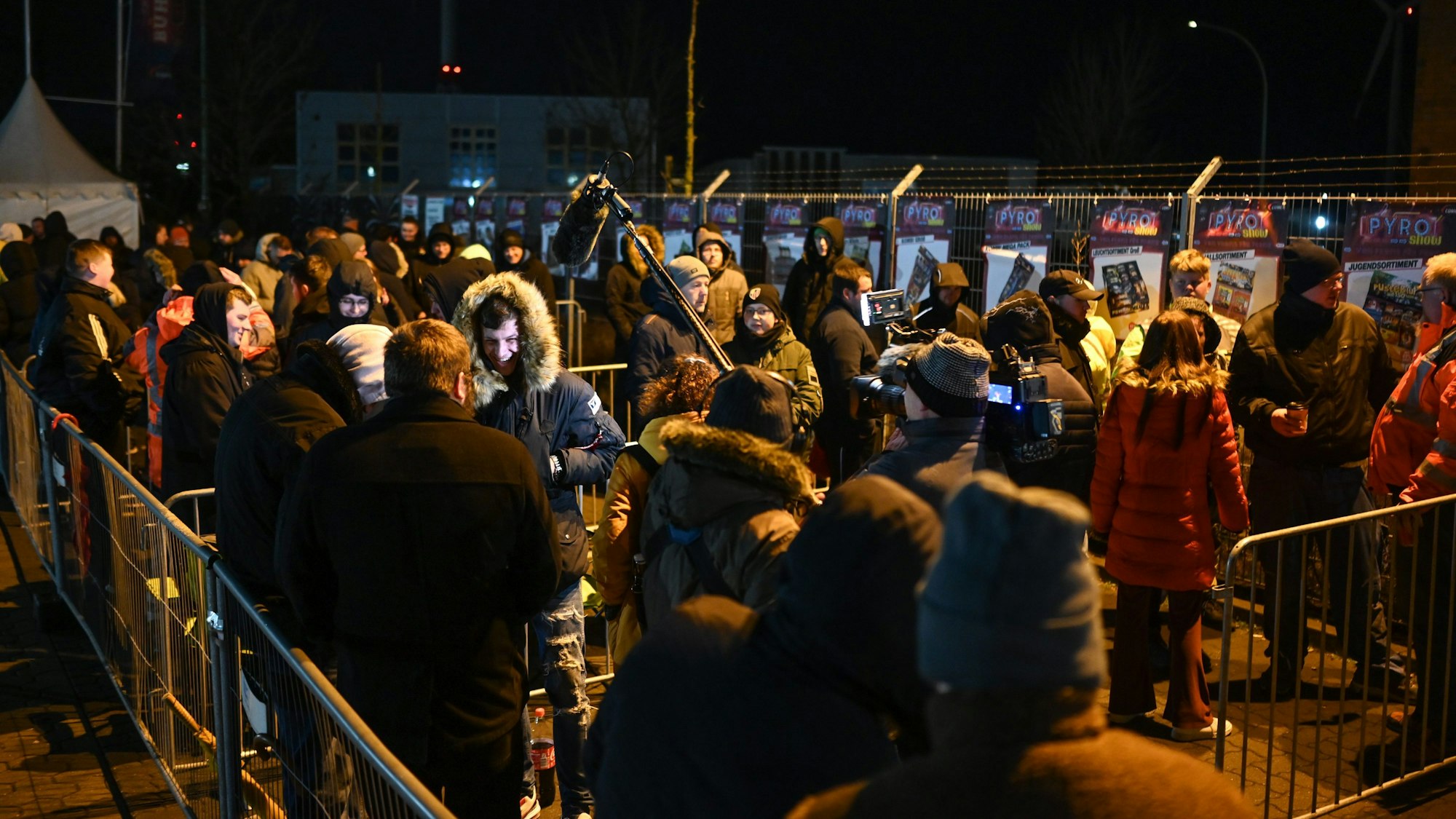 Menschen stehen in langen Warteschlangen vorm Werksverkauf bei Comet um Silvesterfeuerwerk zu kaufen.