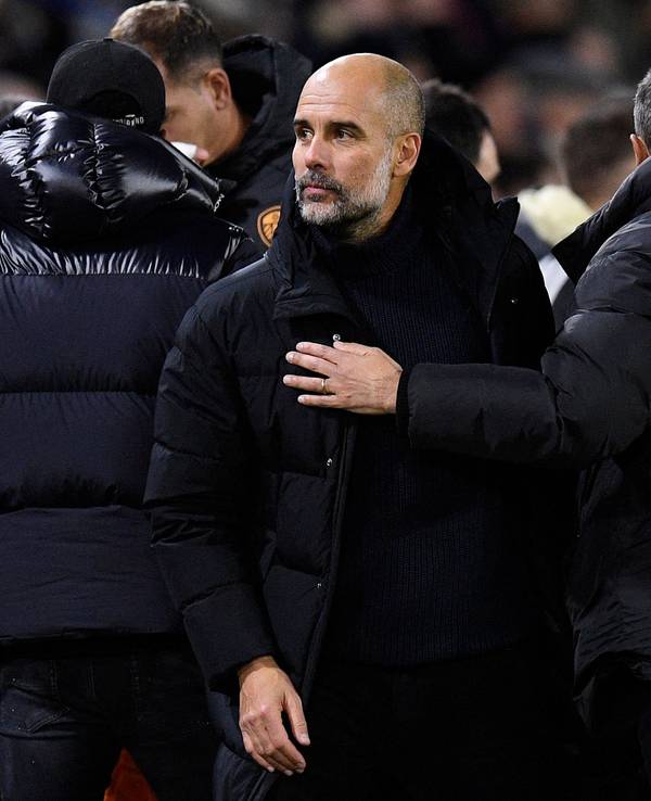 Pep Guardiola inmitten von Menschen.
