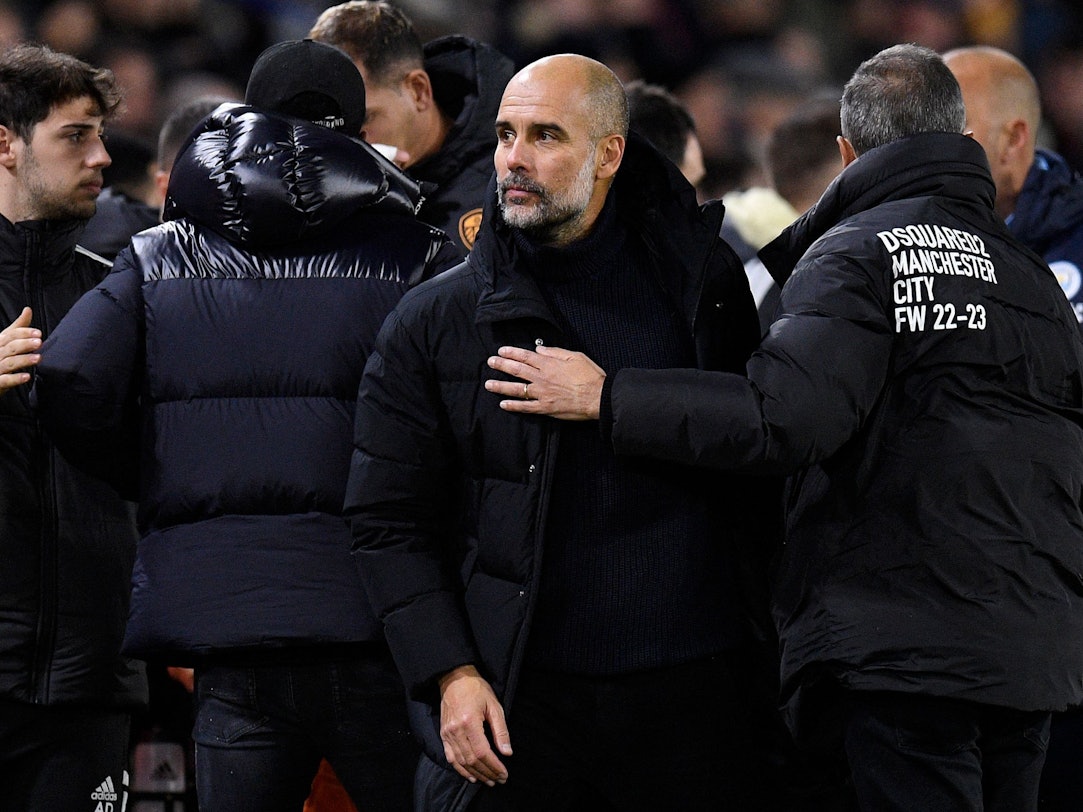 Pep Guardiola inmitten von Menschen.