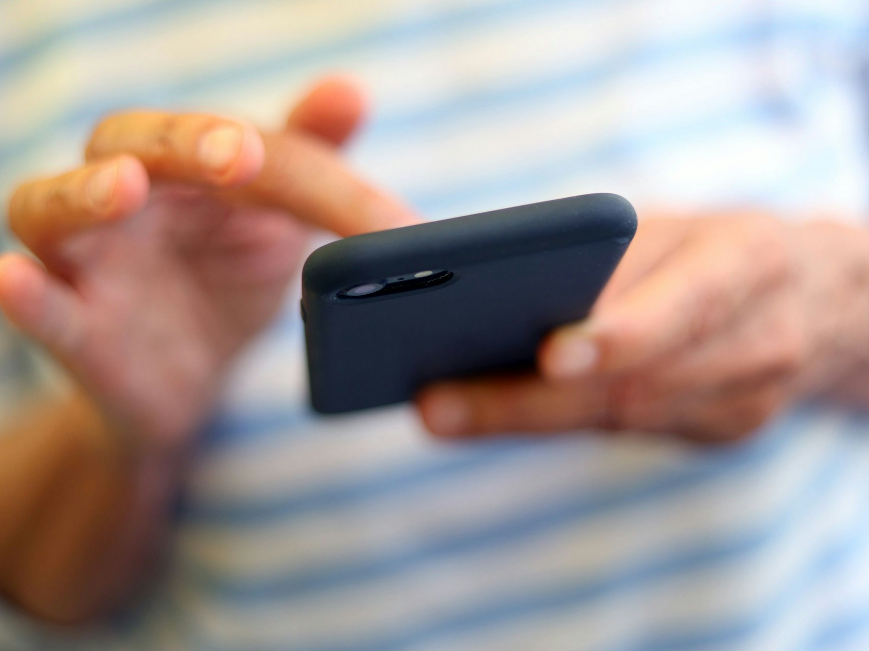 Eine Frau tippt auf einem Smartphone.