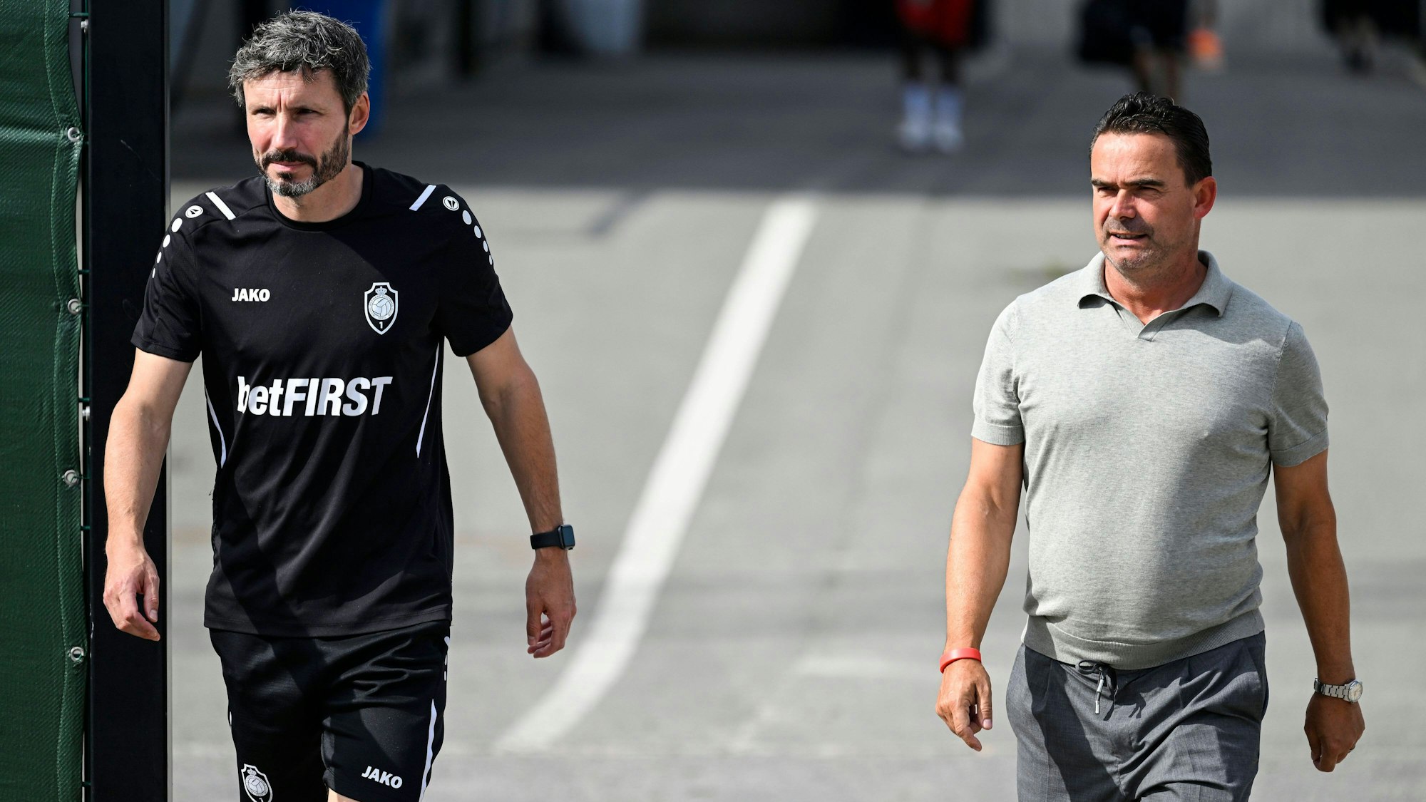 Mark van Bommel und Marc Overmars laufen nebeneinander auf dem Trainingsgelände von Royal Antwerpen.