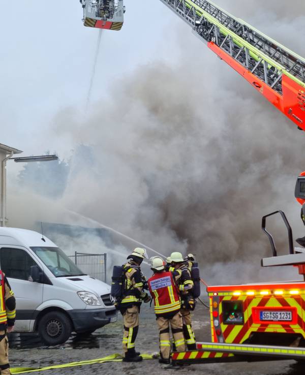 Einsatzkräfte der Feuerwehr Solingen bekämpfen einen Autowerkstatt-Brand.