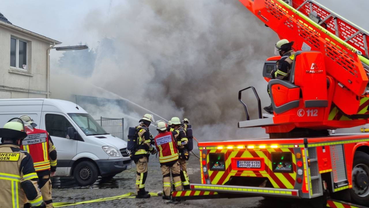 Einsatzkräfte der Feuerwehr Solingen bekämpfen einen Autowerkstatt-Brand.