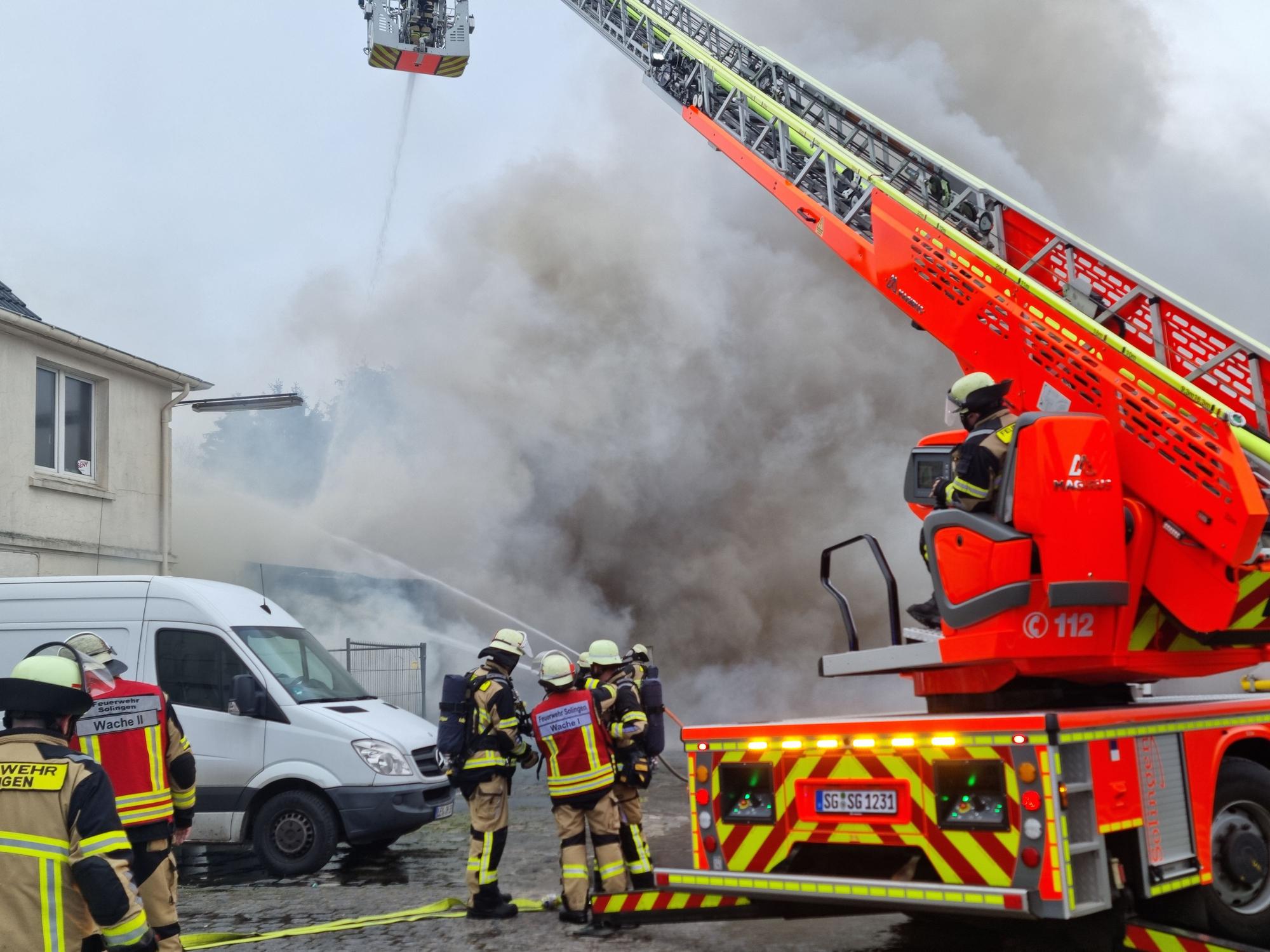 Einsatzkräfte der Feuerwehr Solingen bekämpfen einen Autowerkstatt-Brand.