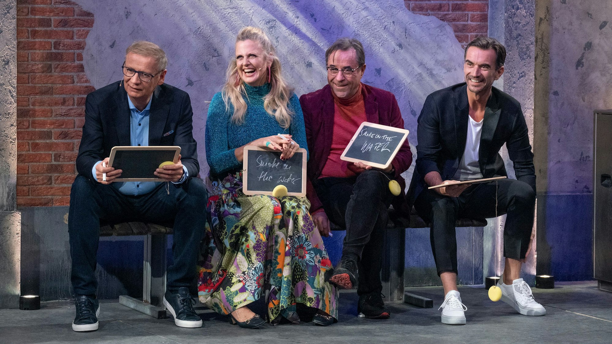 Günther Jauch, Barbara Schöneberger, Jan Josef Liefers und Florian Silbereisen sitzen auf einer Bank nebeneinander.