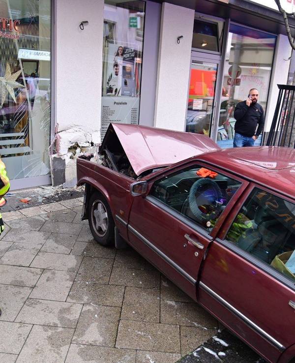 Ein Auto steht in Krefeld auf einem Gehweg, nachdem es in die Hausfassade eines Friseursalons gekracht ist.