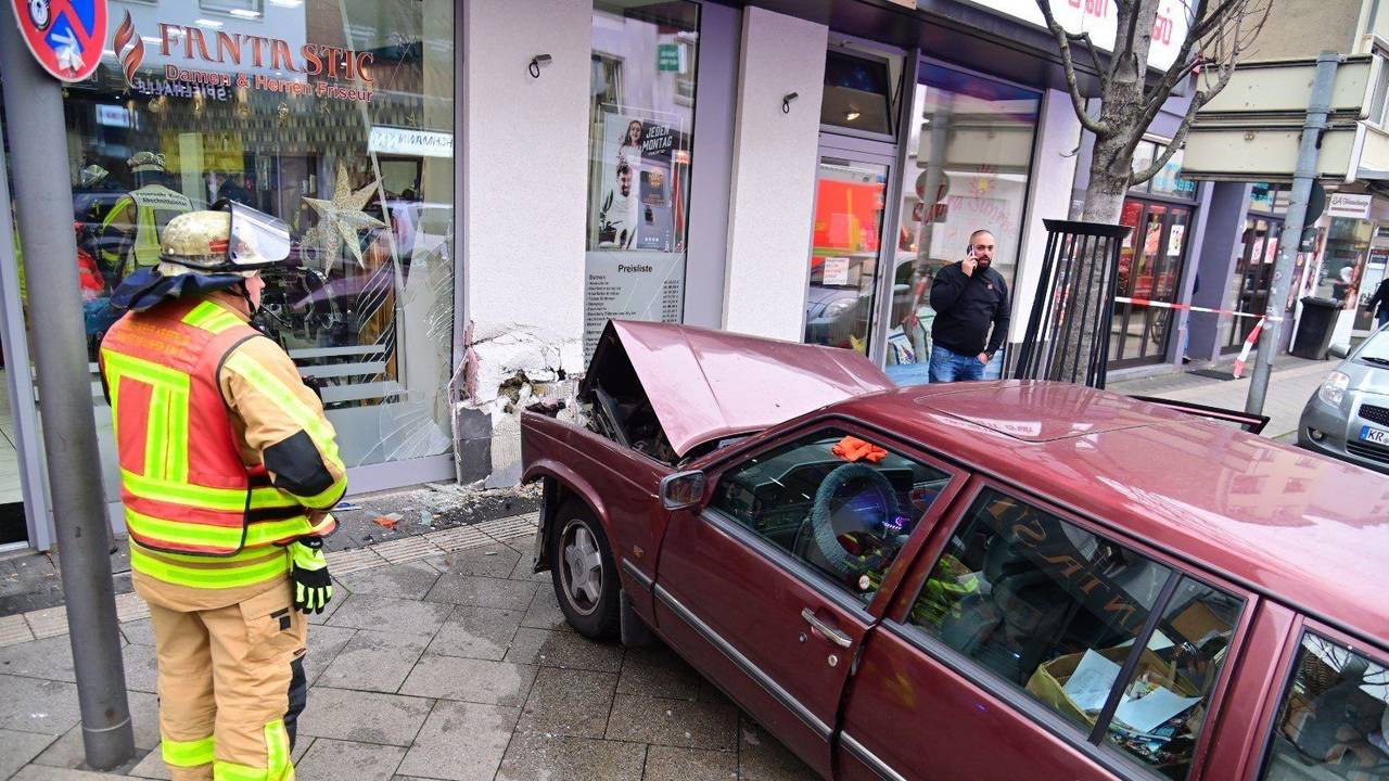 Ein Auto steht in Krefeld auf einem Gehweg, nachdem es in die Hausfassade eines Friseursalons gekracht ist.