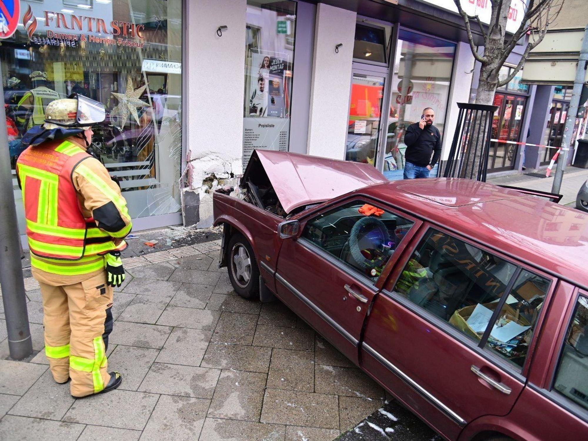 Ein Auto steht in Krefeld auf einem Gehweg, nachdem es in die Hausfassade eines Friseursalons gekracht ist.