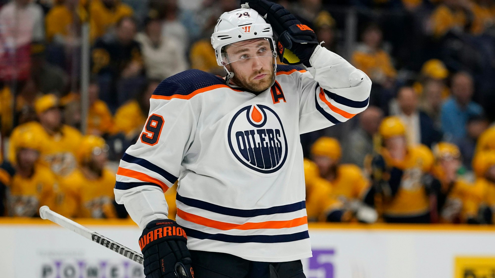 Leon Draisaitl greift sich bei einem Spiel der Edmonton Oilers in der NHL an den Helm.