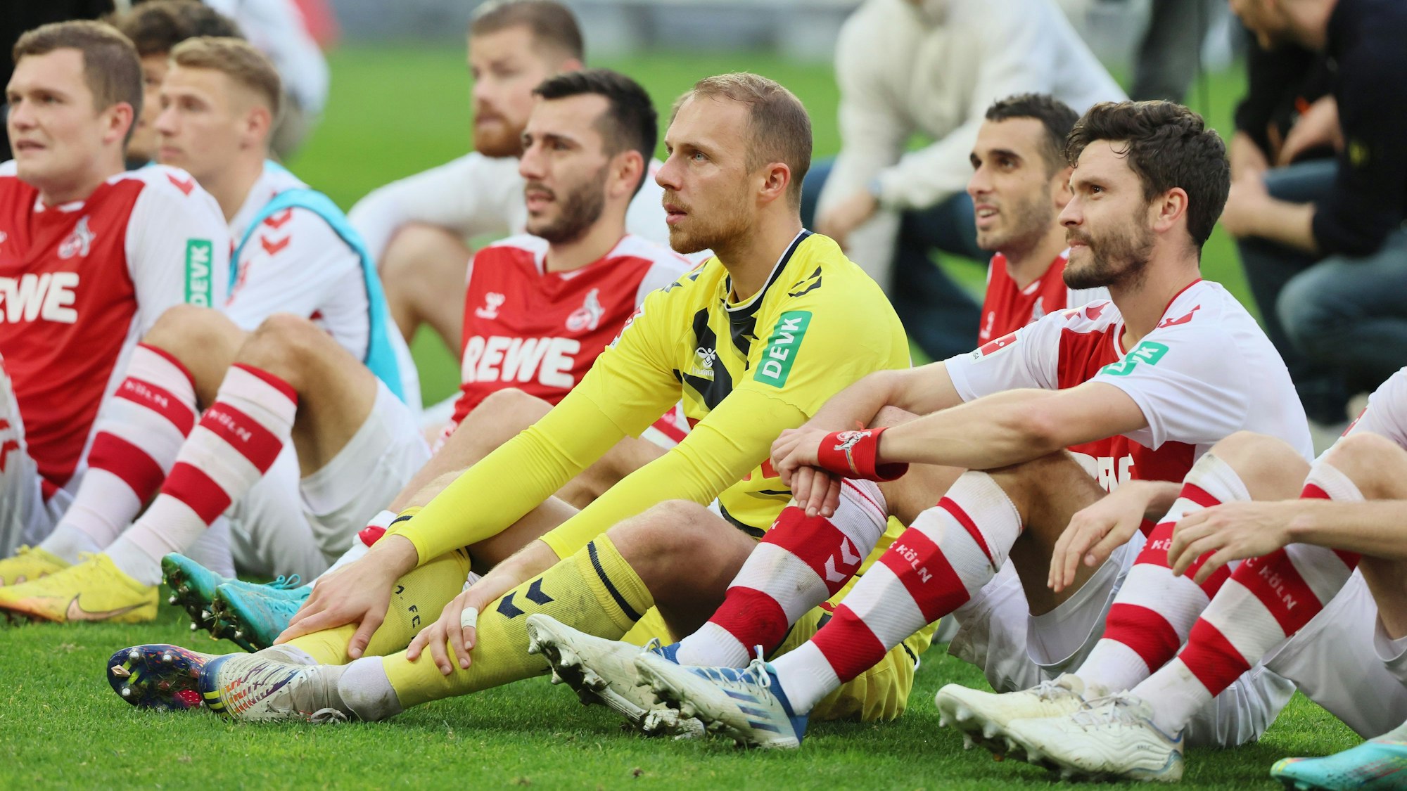 Die Profis des 1. FC Köln sitzen vor der Südkurve im Rhein-Energie-Stadion.