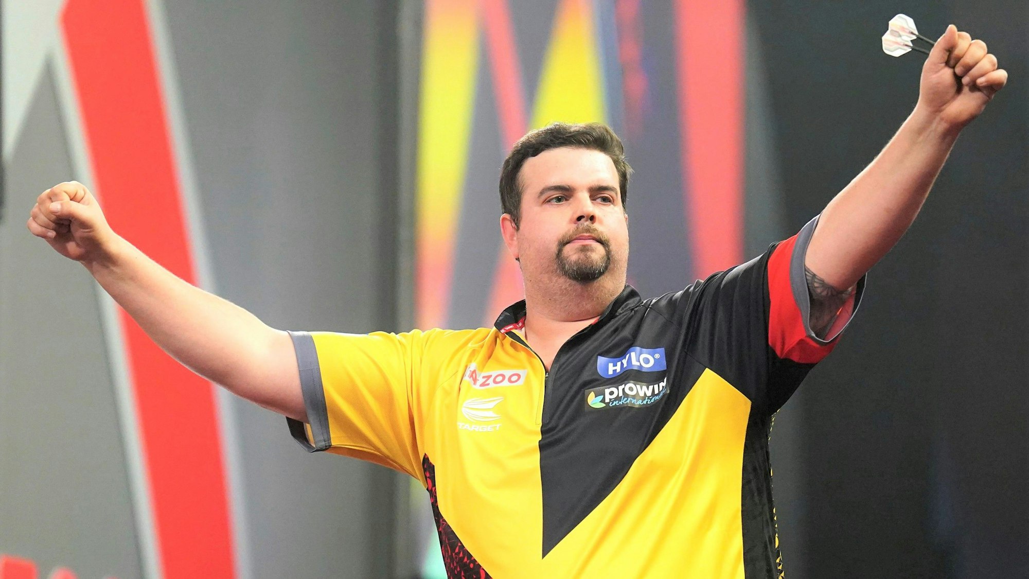 Gabriel Clemens bejubelt den bisher größten Erfolg seiner Laufbahn bei der Darts-WM mit ausgebreiteten Armen auf der Bühne.