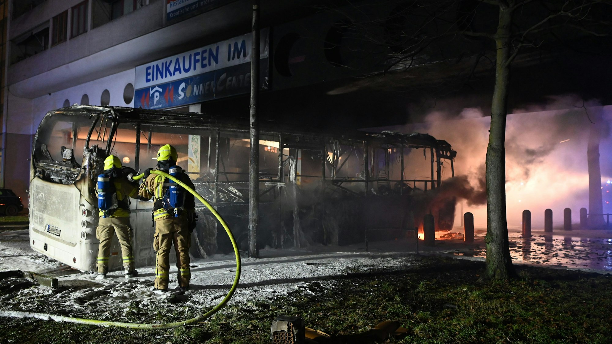 Feuerwehrleute löschen einen Reisebus in Berlin.