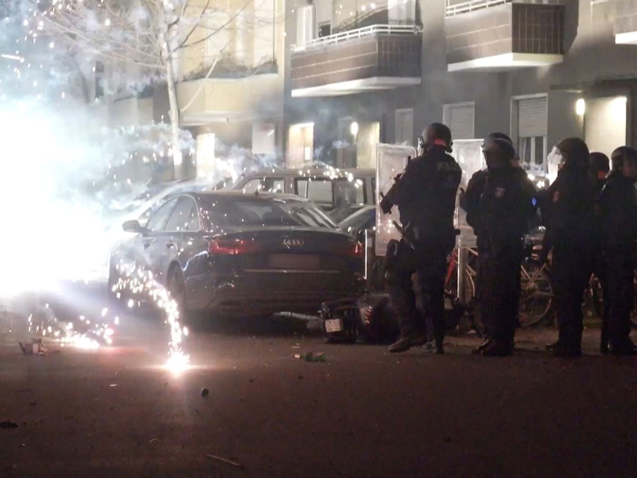 Polizeibeamte stehen hinter explodierendem Feuerwerk. Nach Angriffen auf Einsatzkräfte in der Silvesternacht hat die Diskussion um Konsequenzen begonnen.
