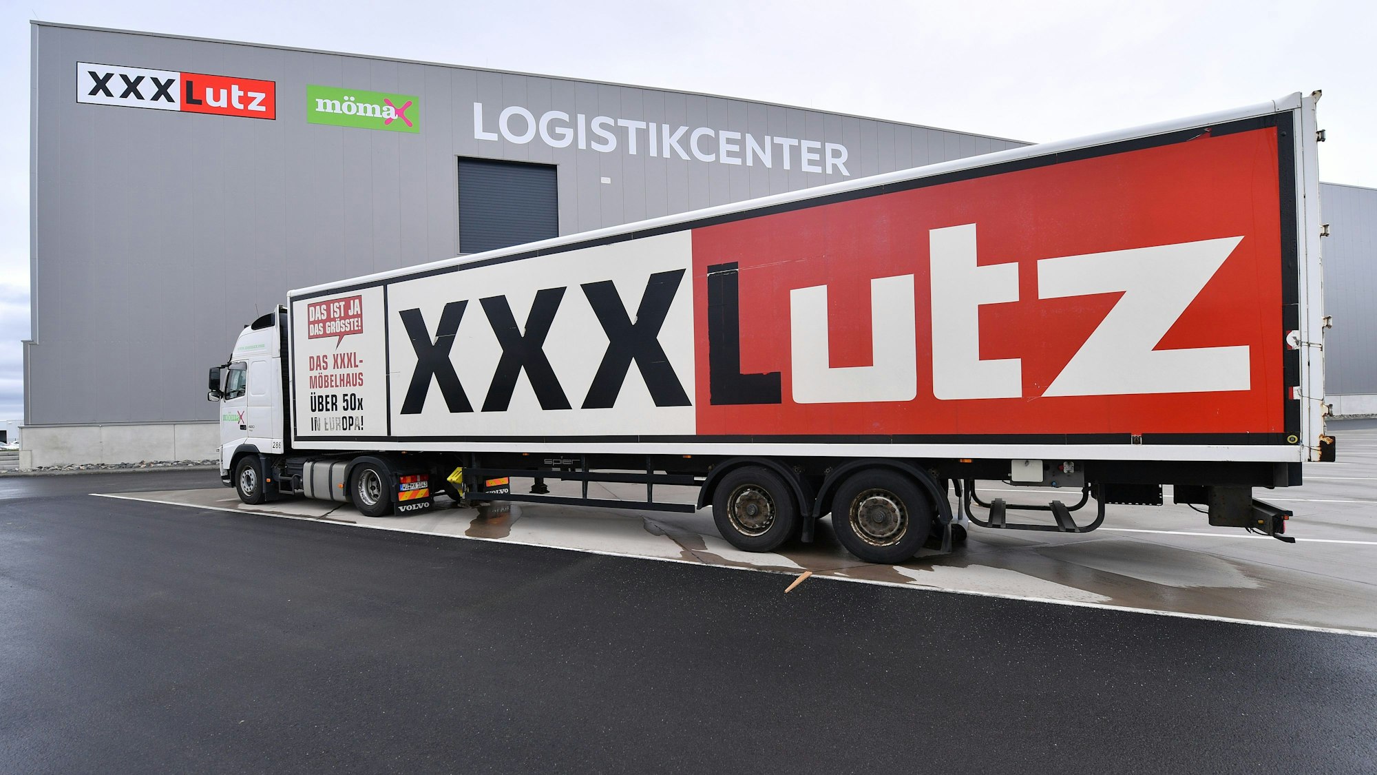 Ein XXXLutz-Laster steht vor einem Logistikcenter des Möbel-Riesen.