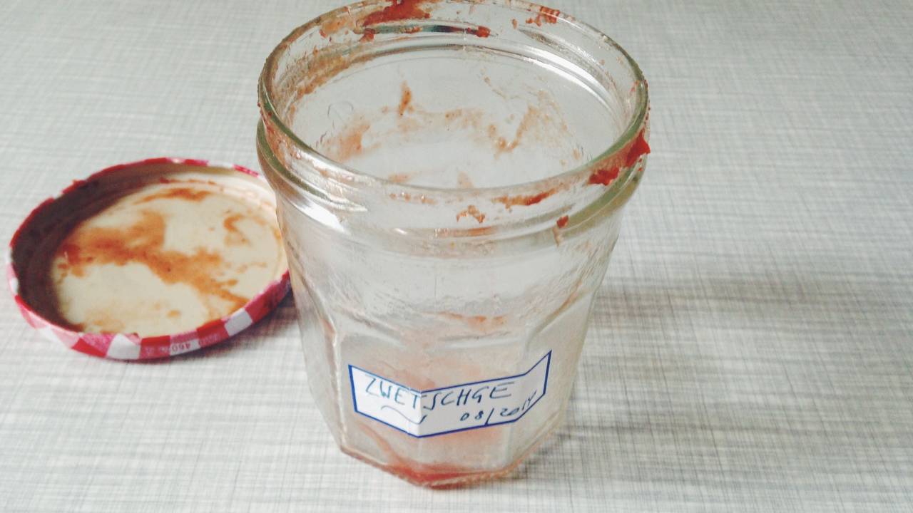 Ein leer gelöffeltes Marmeladenglas mit einem selbstgeschriebenen Etikett.