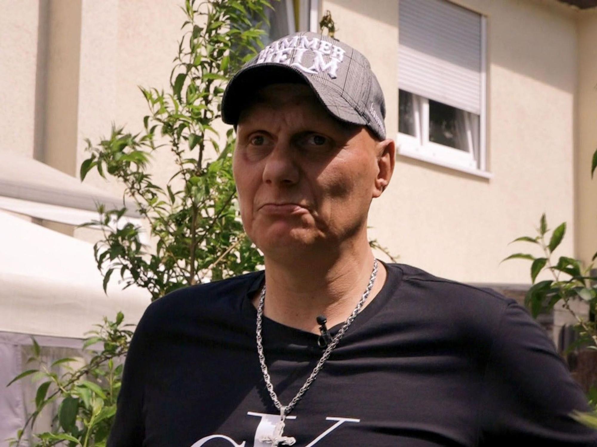 Elvis trägt eine Kappe und ein Kette um den Hals.
