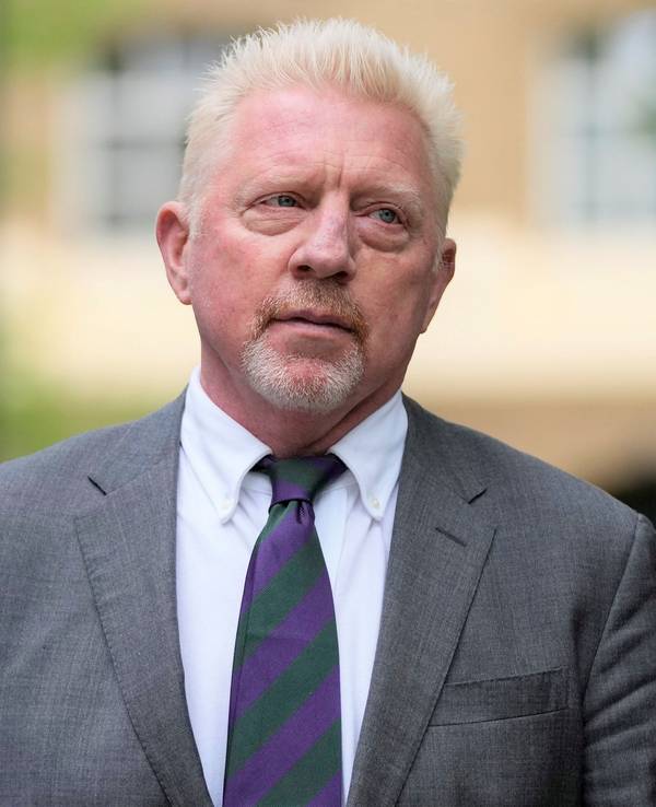 Boris Becker geht nach einem Gerichts-Termin im Anzug auf dem Gerichtsgebäude.