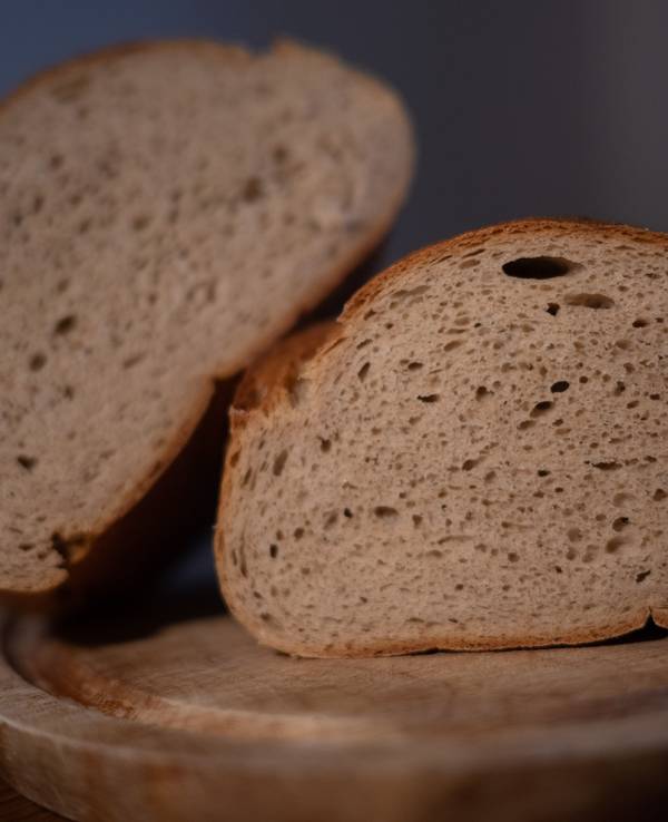Ein aufgeschnittenes Brot liegt auf einem Brett.