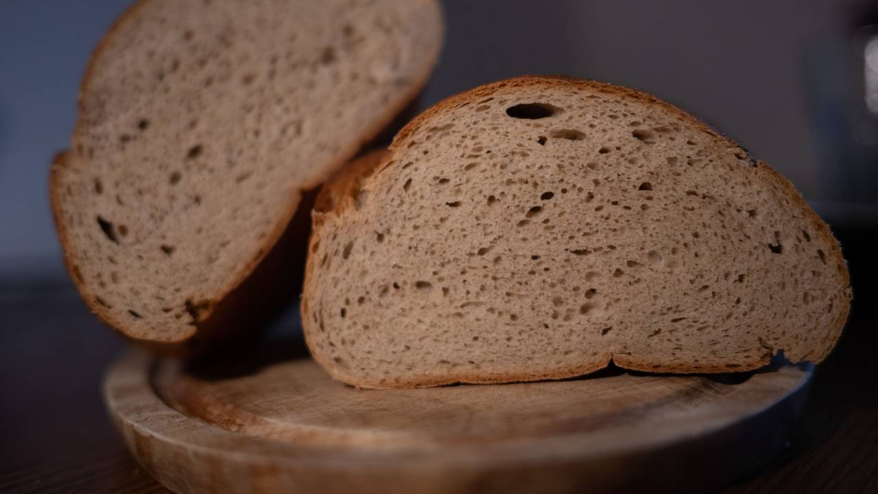 Ein aufgeschnittenes Brot liegt auf einem Brett.