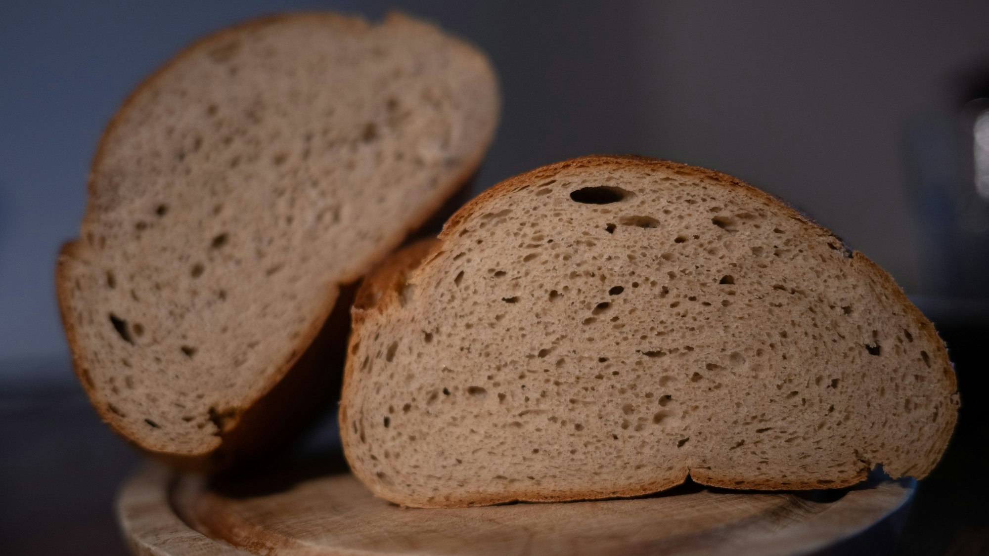 Ein aufgeschnittenes Brot liegt auf einem Brett.