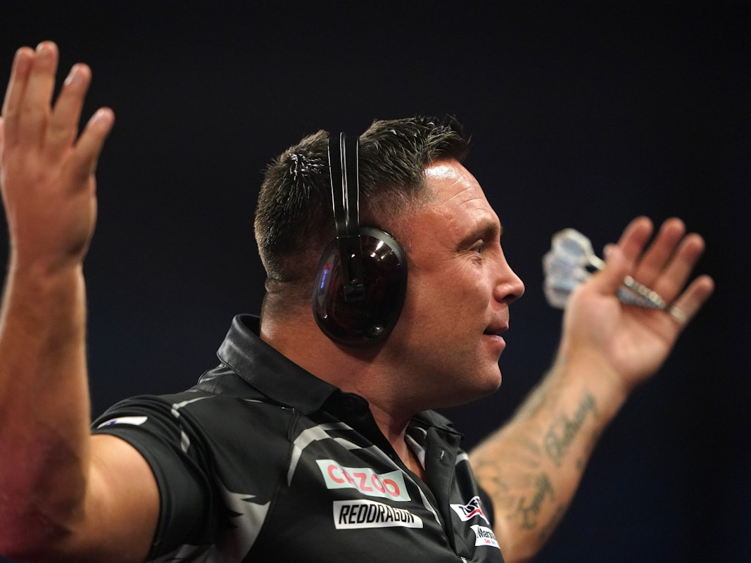 Gerwyn Price spielt das Viertelfinale der Darts-WM am Neujahrstag 2023 mit Gehörschutz und gestikuliert Richtung Publikum
