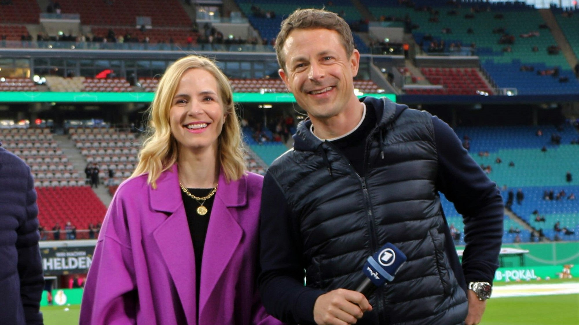 Alexander Bommes und Stephanie Müller-Spirra posieren vor einer ARD-Übertragung für die Kamera.