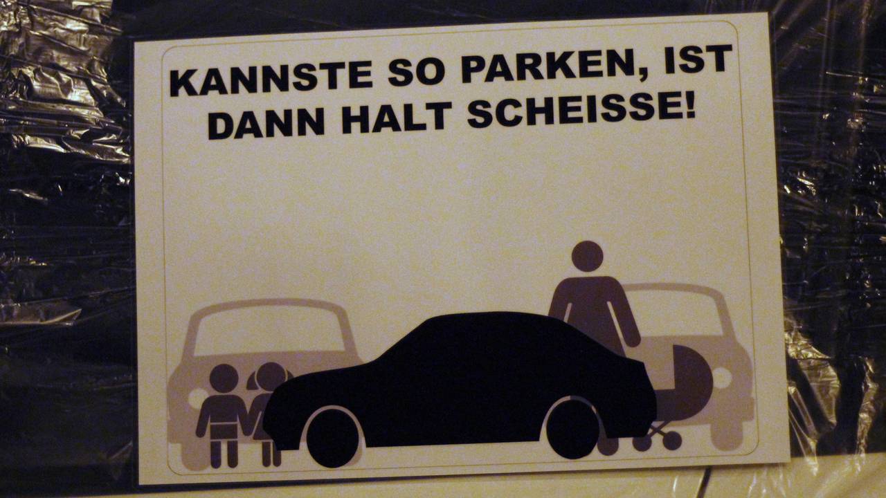 Das Symbolfoto zeigt einen Zettel an einer Autoscheibe mit den Worten "Kannste so parken, ist dann halt scheisse!".