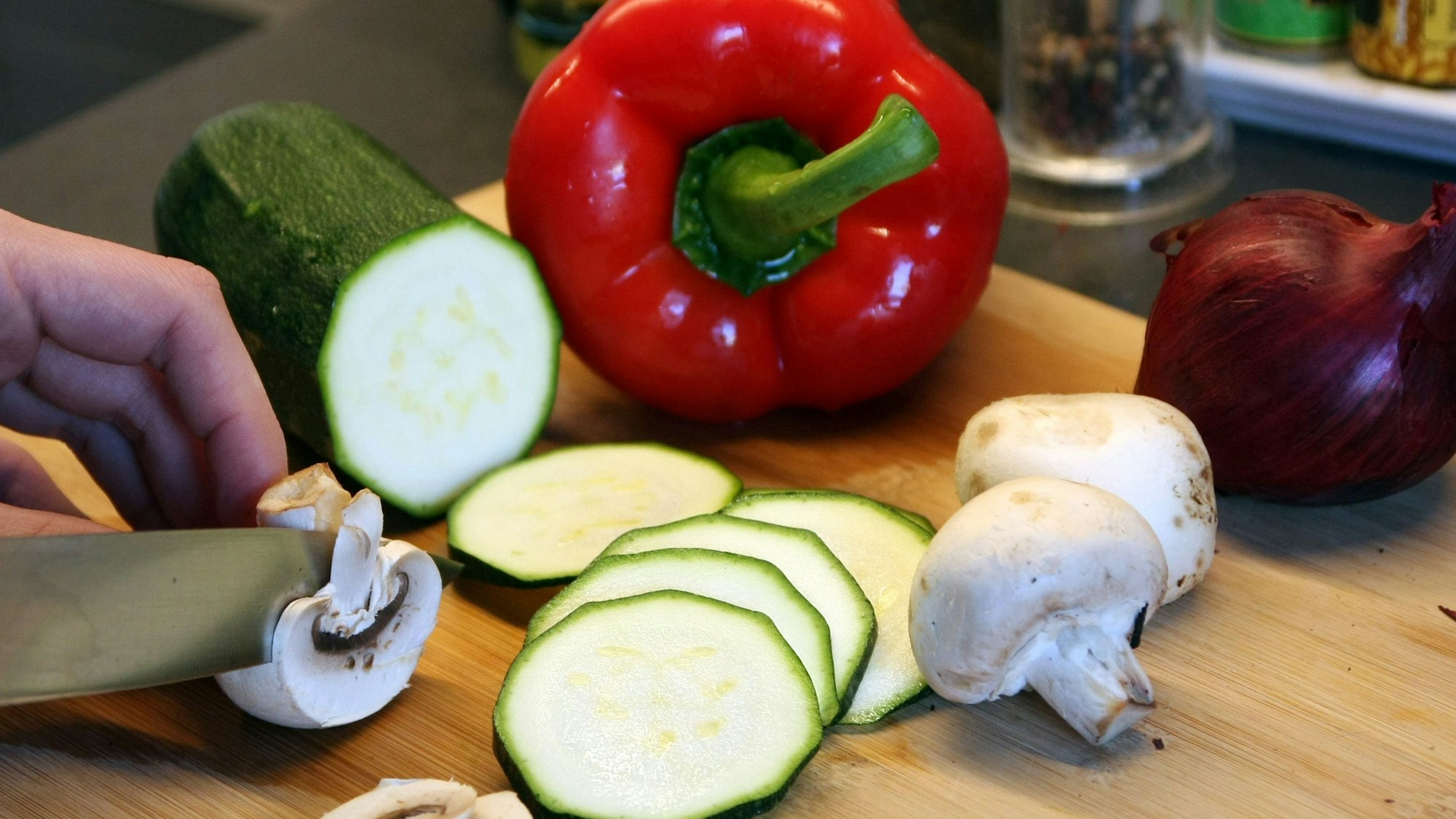 Ein Mann schneidet Gemüse.