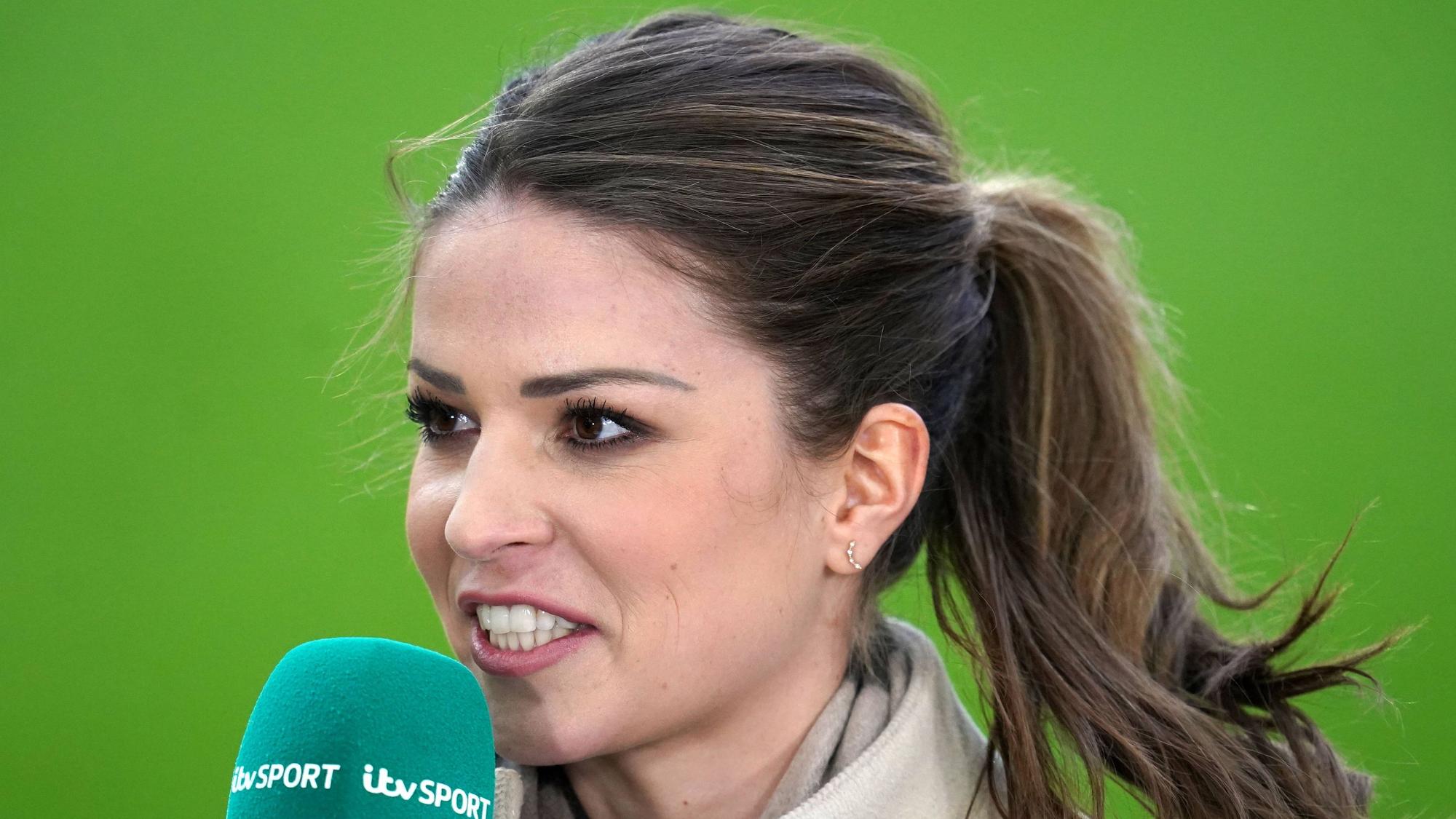 Nationalspielerin Melanie Leupolz steht mit MIkrofon im Mantel auf dem Rasen.