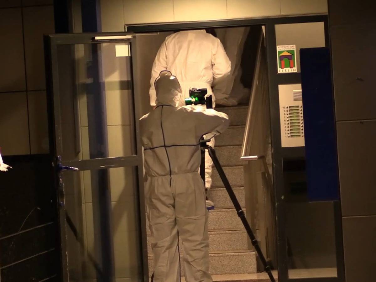 Mitarbeiter der Spurensicherung sind in einem Treppenhaus, einer von ihnen hat ein Stativ aufgestellt.