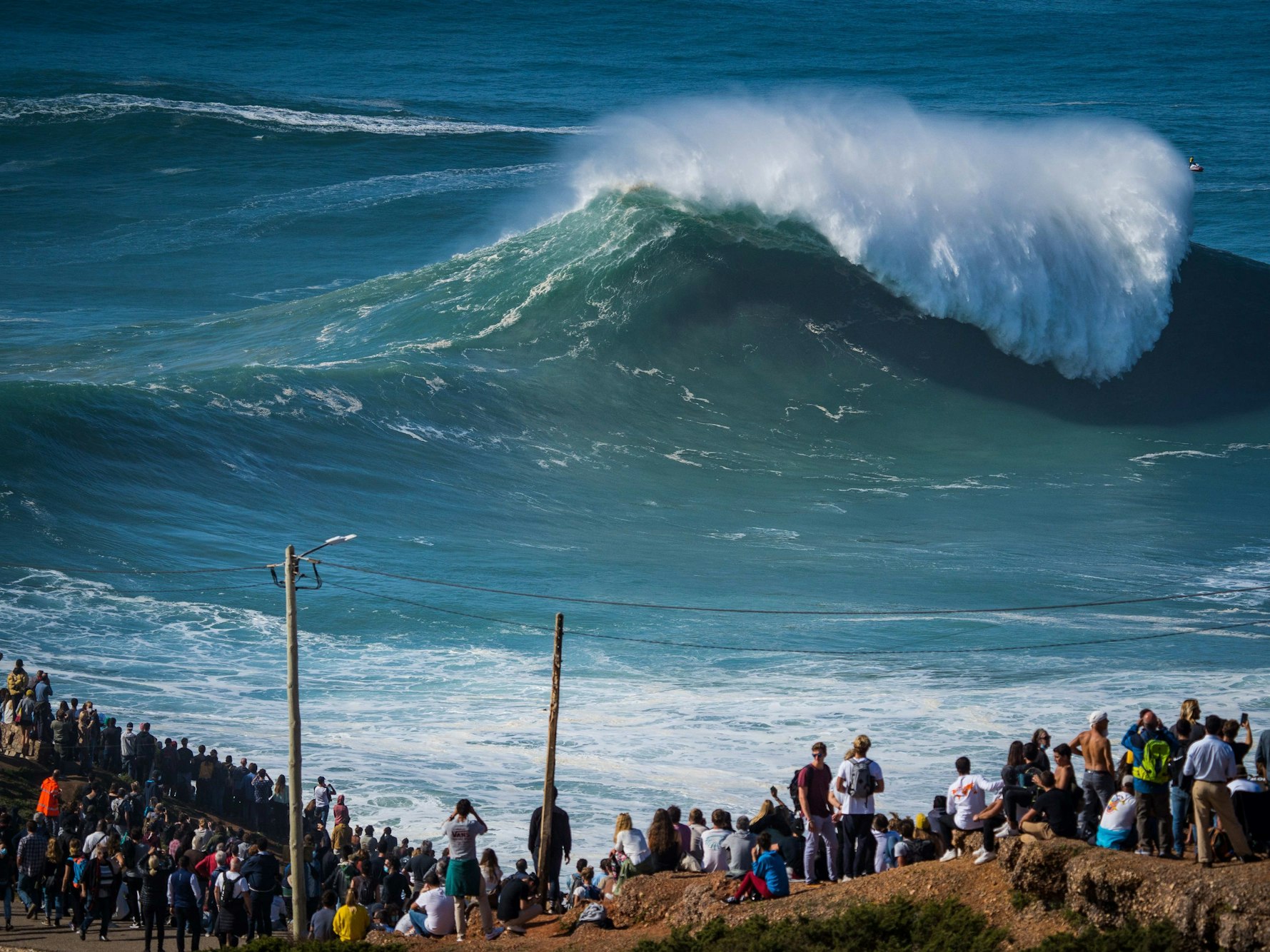 Menschen beobachten von der Küste eine Riesenwelle im portugiesischen Nazare.
