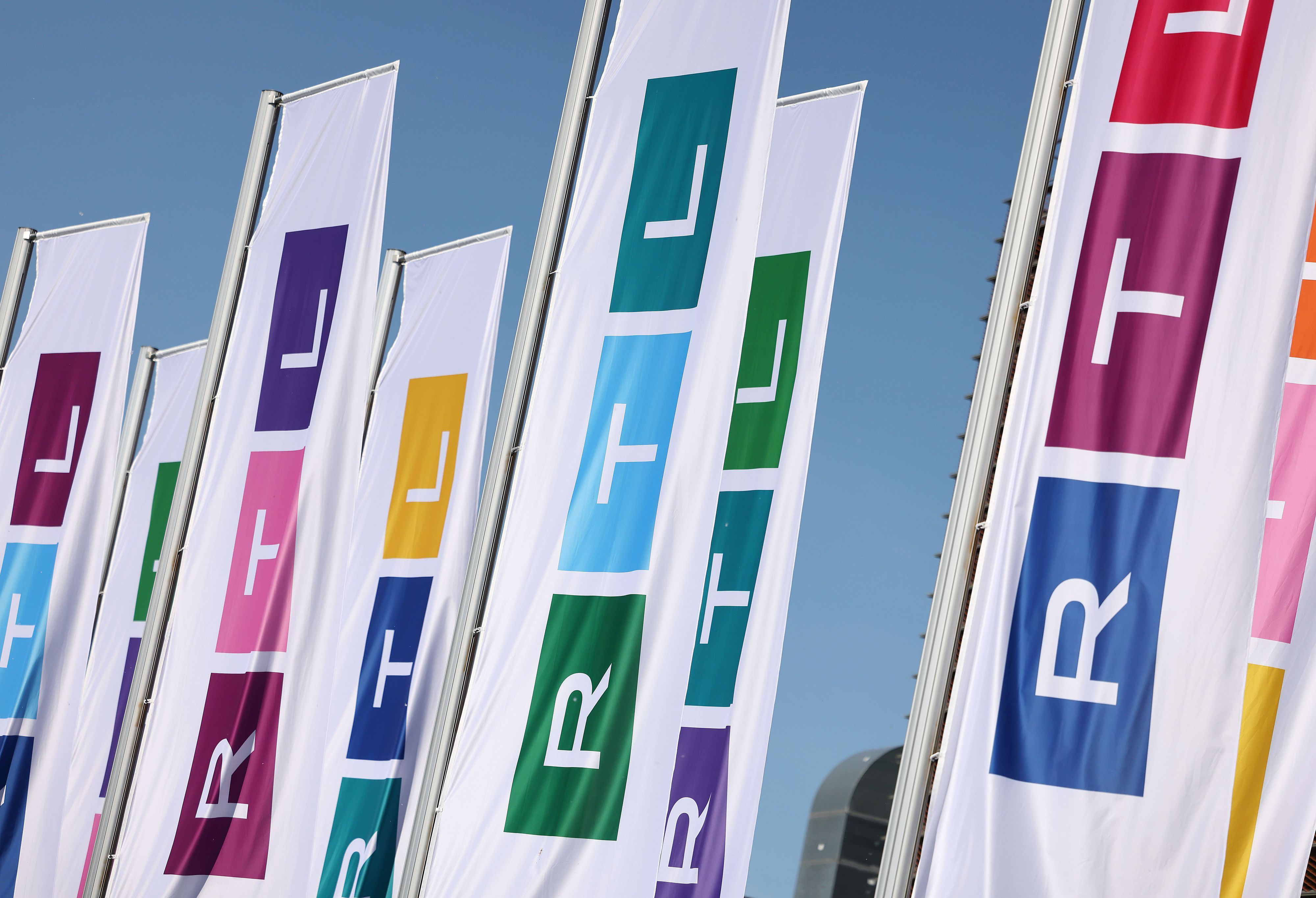 Fahnen mit dem neuen Logo des Fernsehsenders RTL wehen vor dem Gebäude.